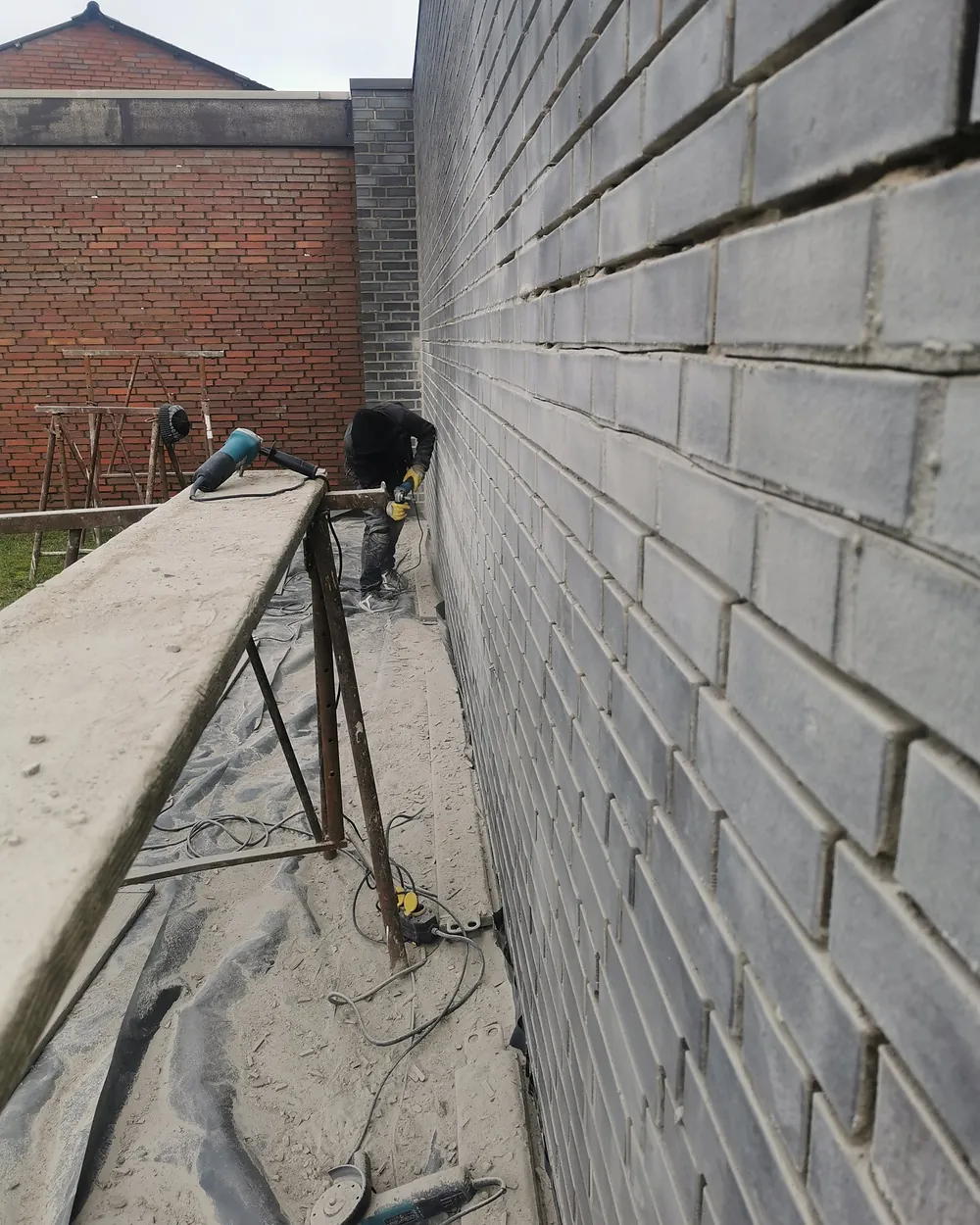 Verfugarbeiten an einer Klinkerfassade aus dem Gerüst